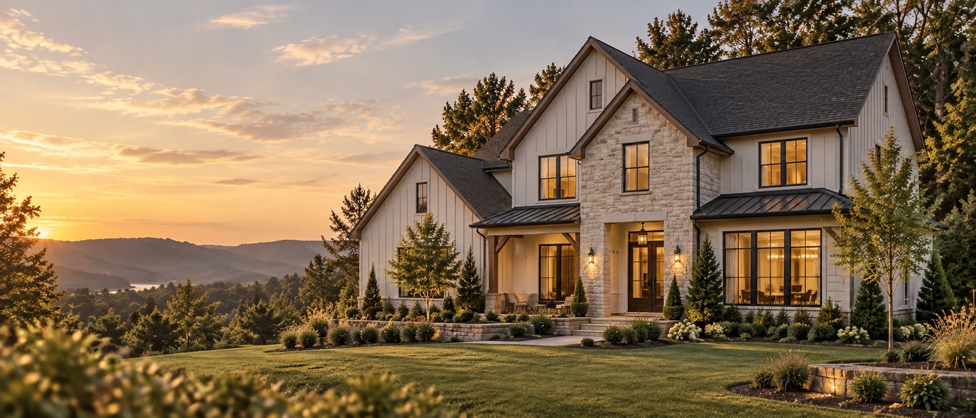 A two-story home at golden hour, windows warmly lit, with the Tennessee Valley ridges behind it