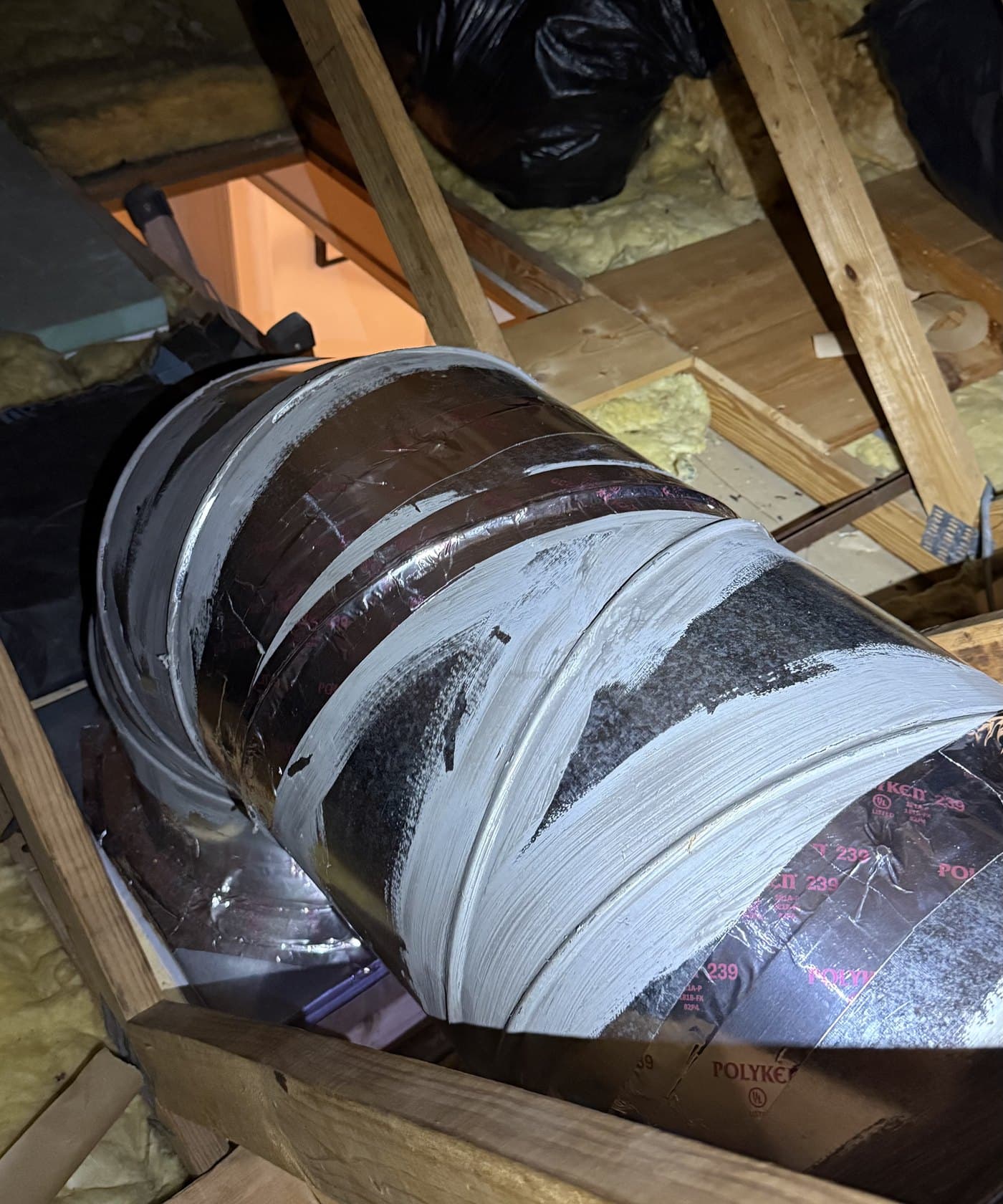 An attic supply trunk with its seams and joints sealed in mastic during a duct repair