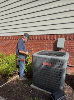 Russell inspecting a large outdoor heat pump unit during a diagnostic visit