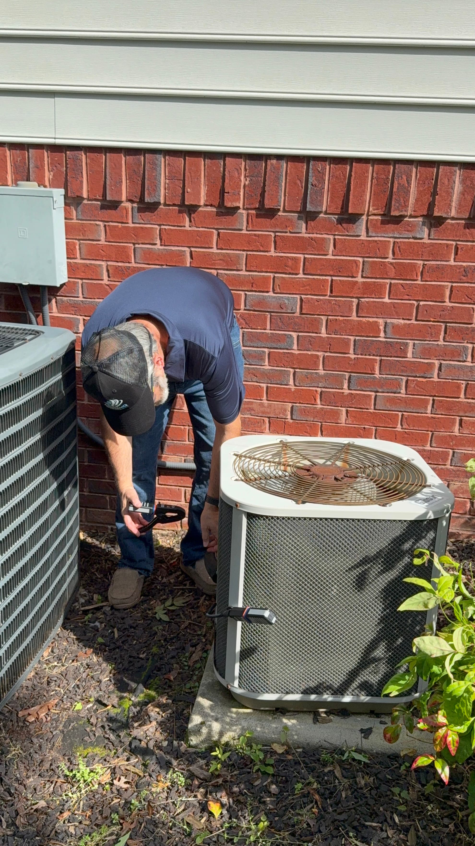 Russell servicing an outdoor AC condenser unit during a diagnostic repair visit