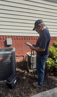 Russell recording heating-system diagnostic readings on an iPad during a service call