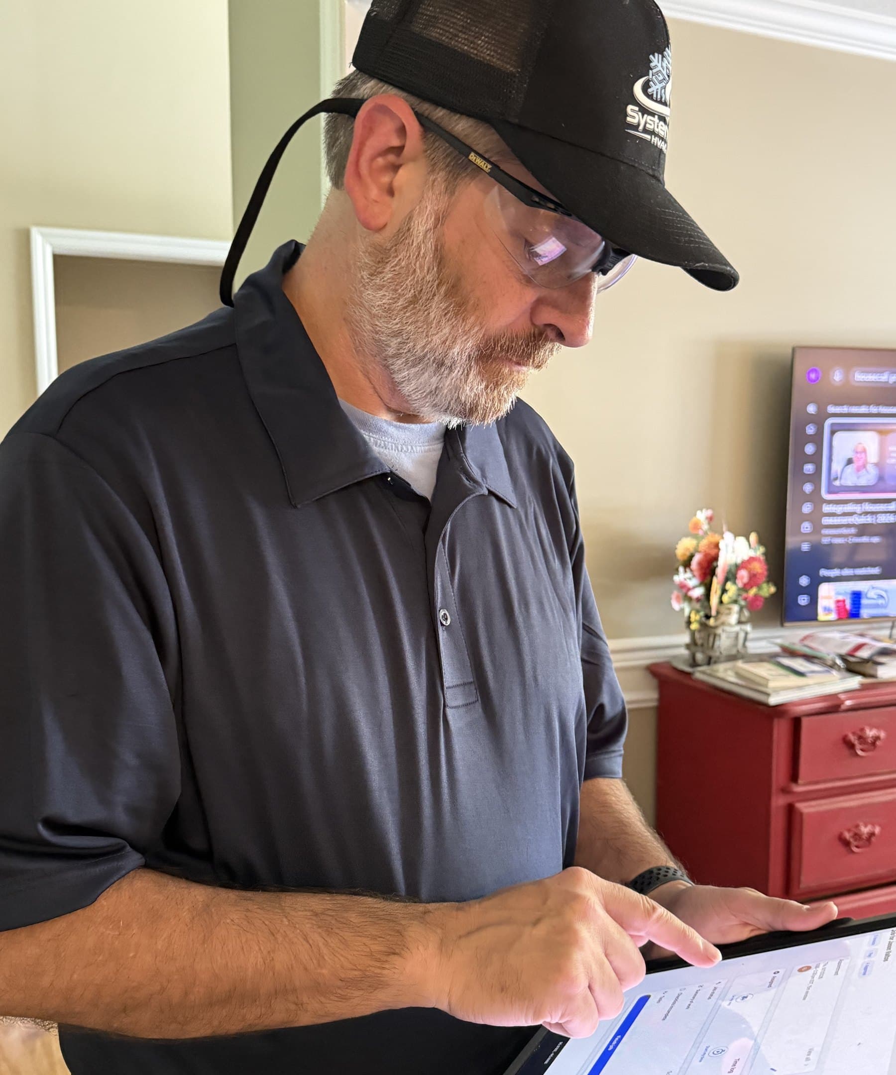 Russell, owner of SystemIQ HVAC, reviewing job details on a tablet